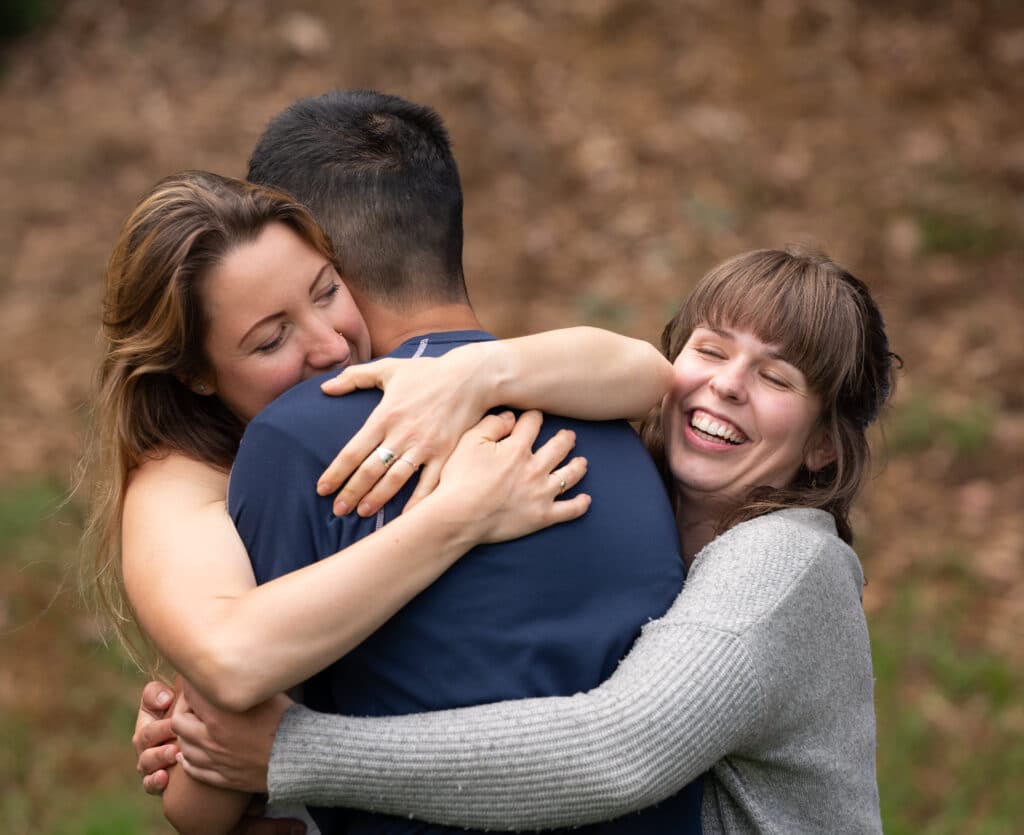 Three people hugging